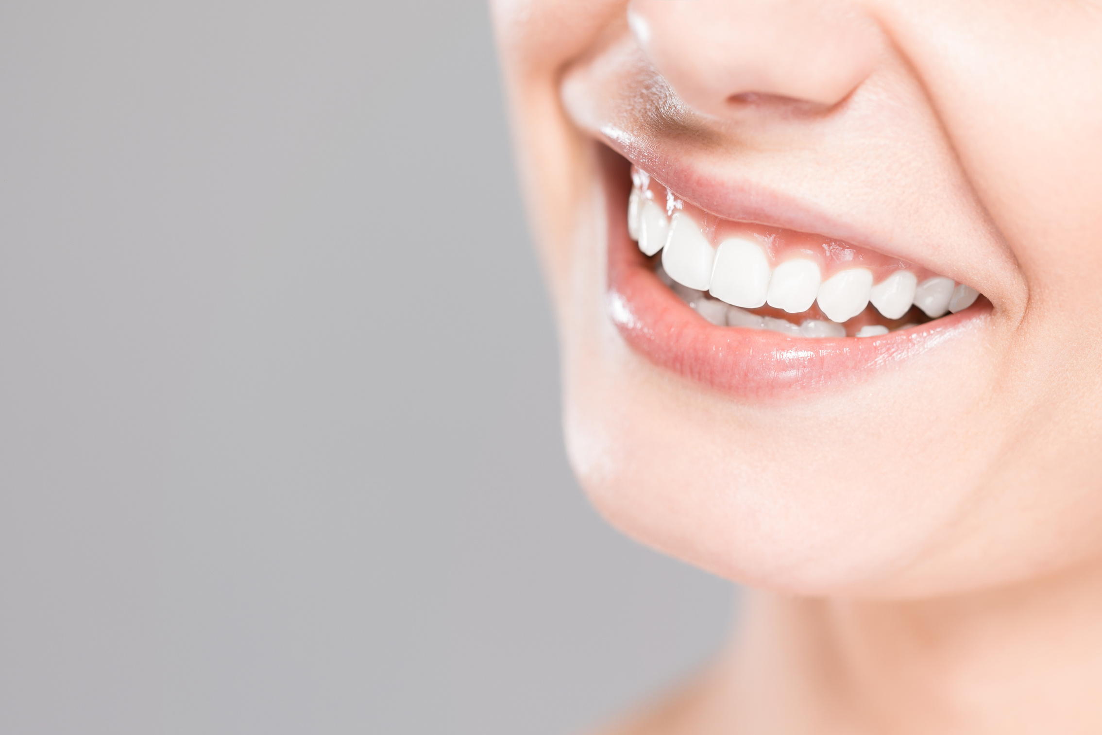 Smiling Woman's Teeth Closeup on Gray Studio Background